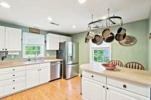 84 E Ave, Lowell, MA 01854 - kitchen with stainless steel appliances, healthy amount of natural light, white cabinets, light countertops, and recessed lighting