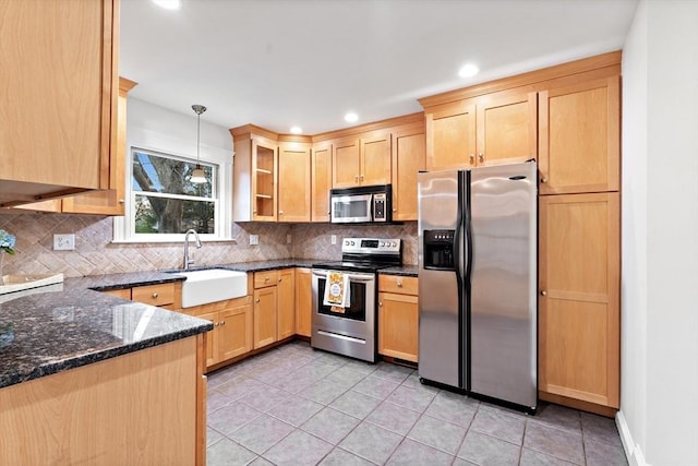 kitchen with appliances with stainless steel finishes, a sink, and light brown cabinets
