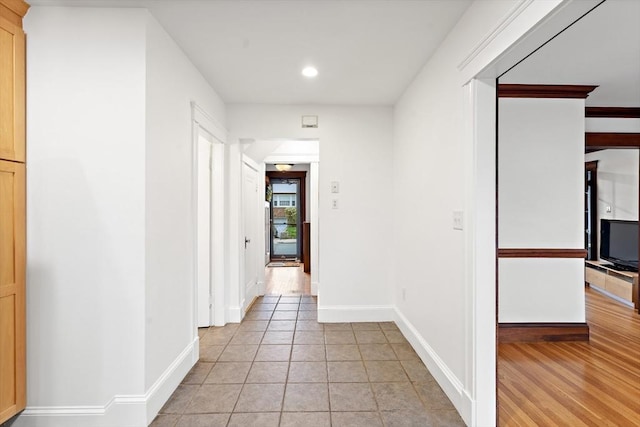 hallway featuring light tile patterned floors, baseboards, and recessed lighting