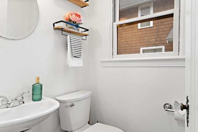 half bathroom featuring toilet and a sink