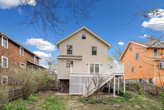 back of property with stairs, fence, and a deck