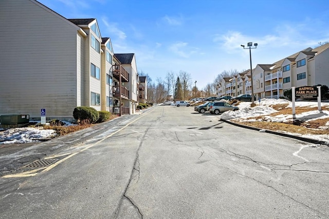 view of street with street lighting, a residential view, and curbs