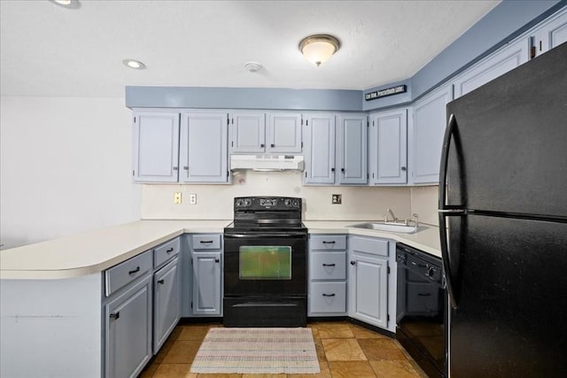 kitchen with light countertops, gray cabinetry, a peninsula, under cabinet range hood, and black appliances