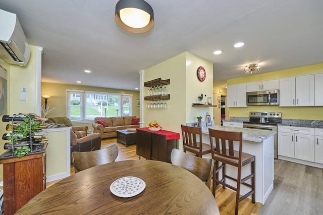 dining space with light wood-style flooring, recessed lighting, and a wall mounted AC
