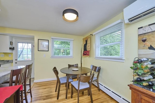 dining space featuring a wall unit AC, light wood-style floors, a baseboard radiator, and plenty of natural light