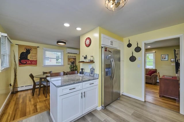 kitchen with stainless steel refrigerator with ice dispenser, white cabinetry, light stone counters, light wood-style floors, and recessed lighting