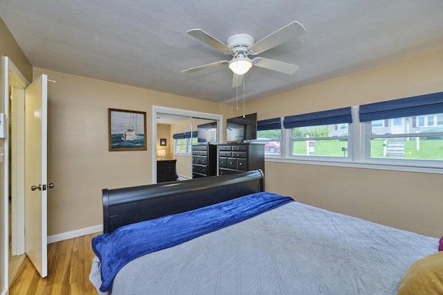 bedroom featuring wood finished floors, baseboards, and a ceiling fan