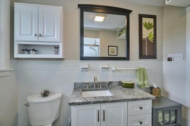 bathroom with tile walls, vanity, and toilet