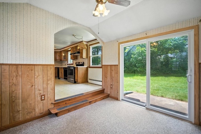 69 Michael St, Ludlow, MA 01056 - unfurnished living room with wallpapered walls, a wainscoted wall, arched walkways, wood walls, and a baseboard heating unit