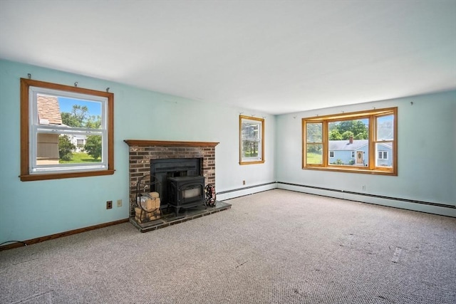 69 Michael St, Ludlow, MA 01056 - unfurnished living room featuring a wood stove, plenty of natural light, carpet, and a baseboard radiator