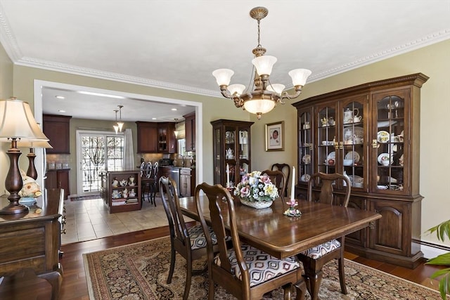 dining room featuring an inviting chandelier, ornamental molding, baseboard heating, and dark wood-style flooring