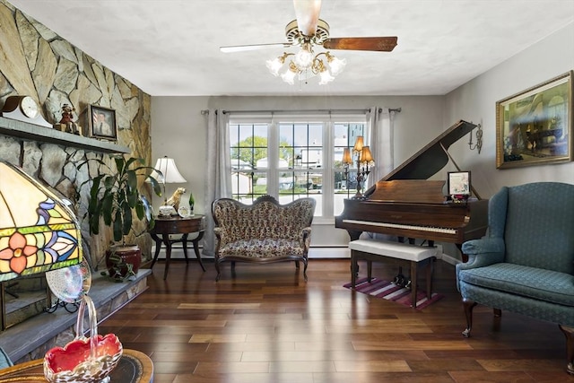 living area featuring a ceiling fan, a baseboard heating unit, and wood finished floors