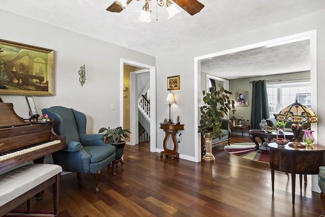 sitting room featuring ceiling fan, wood finished floors, and stairway