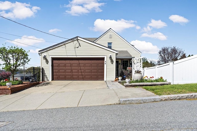 view of front of house featuring fence, concrete driveway, and a garage