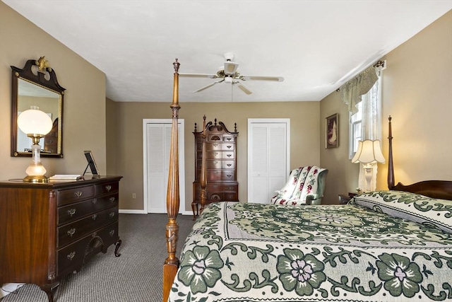 bedroom featuring a ceiling fan, baseboards, multiple closets, and dark carpet