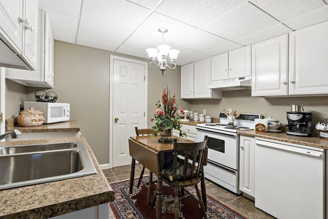 kitchen with white cabinets, a sink, white appliances, a paneled ceiling, and under cabinet range hood