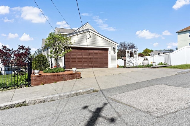 single story home with concrete driveway, fence, and a garage