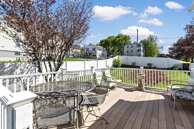 deck with outdoor dining area and a fenced backyard
