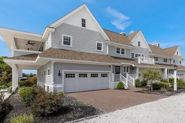 33 Central Ave Unit 12, Scituate, MA 02050 - shingle-style home with an attached garage, decorative driveway, ceiling fan, roof with shingles, and a balcony