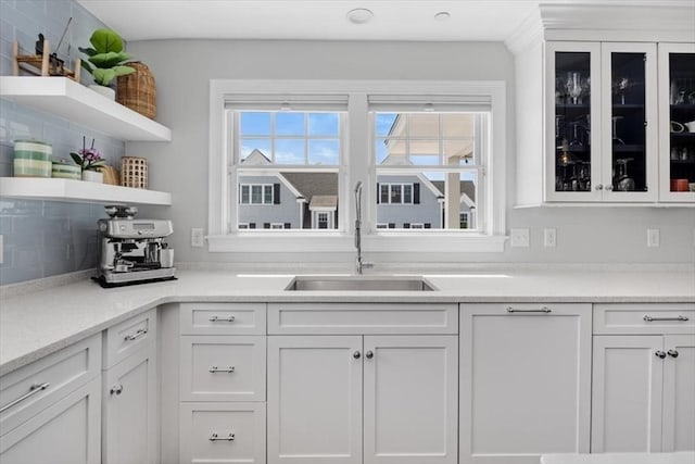 33 Central Ave Unit 12, Scituate, MA 02050 - kitchen featuring open shelves, white cabinets, glass insert cabinets, and a sink
