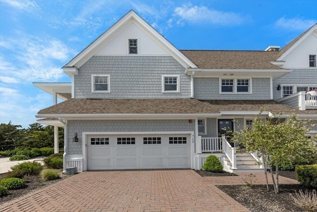 33 Central Ave Unit 12, Scituate, MA 02050 - view of front of house featuring an attached garage, decorative driveway, and roof with shingles