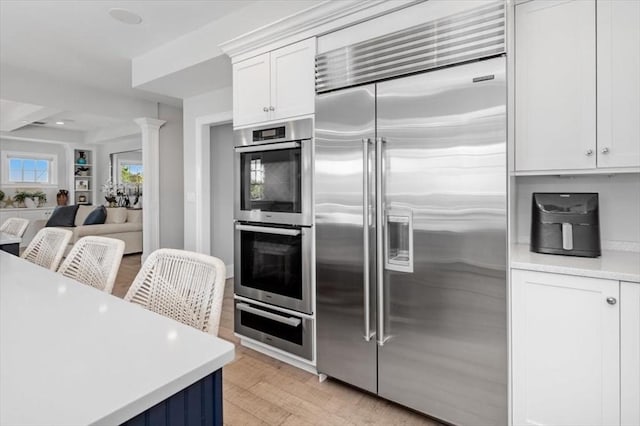 33 Central Ave Unit 12, Scituate, MA 02050 - kitchen featuring stainless steel appliances, light countertops, a warming drawer, white cabinets, and open floor plan