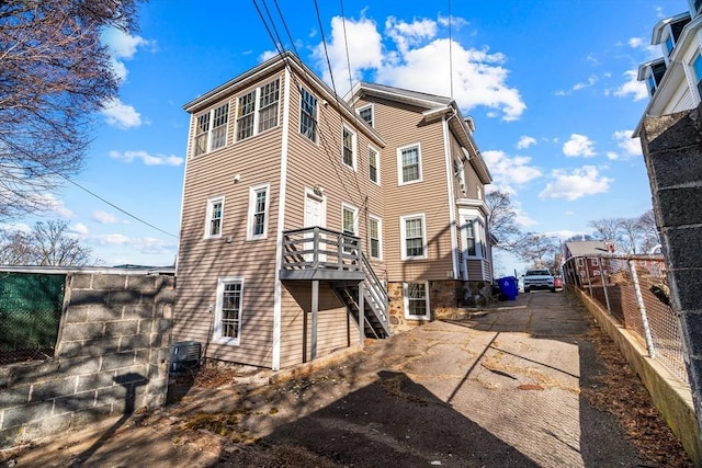 21 Alpine Unit 2Nd & 3Rd, Boston, MA 02119 - back of house featuring stairway, a wooden deck, and driveway