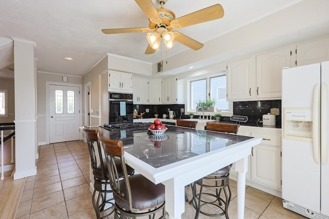 3 Nira St, Malden, MA 02148 - kitchen with white fridge with ice dispenser, black oven, decorative backsplash, white cabinets, and crown molding