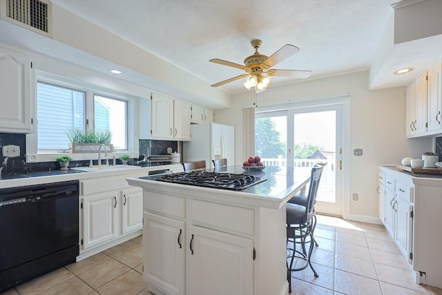 3 Nira St, Malden, MA 02148 - kitchen featuring black dishwasher, white refrigerator with ice dispenser, stainless steel gas cooktop, a kitchen bar, and backsplash