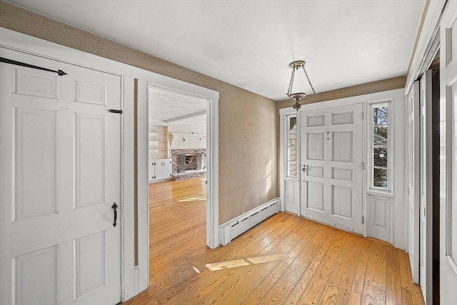 entrance foyer featuring a baseboard radiator and light hardwood / wood-style flooring