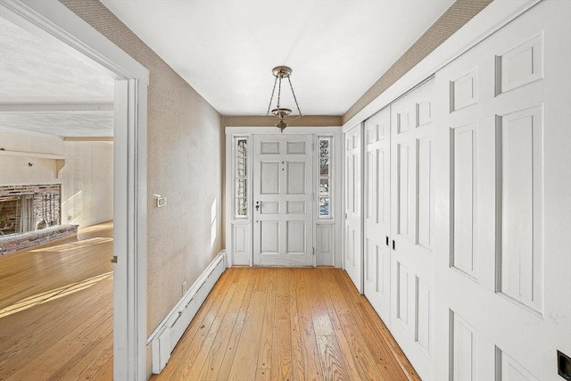 doorway featuring a baseboard heating unit and light wood-type flooring