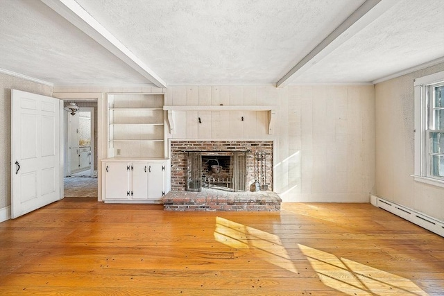 unfurnished living room featuring beamed ceiling, a brick fireplace, a textured ceiling, and light hardwood / wood-style flooring