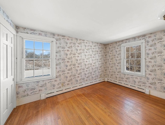 spare room with wood-type flooring and baseboard heating