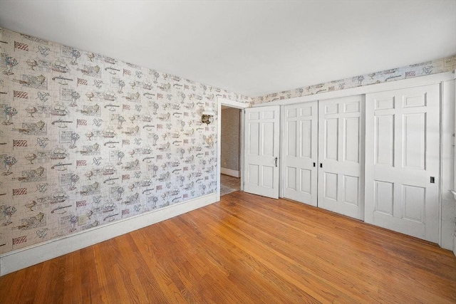 unfurnished bedroom with hardwood / wood-style floors and a closet