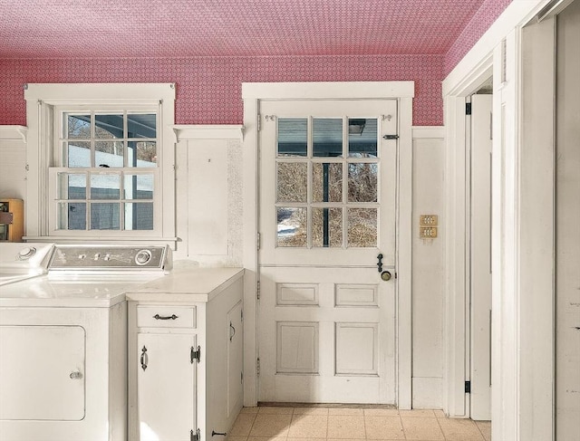 clothes washing area featuring cabinets and independent washer and dryer