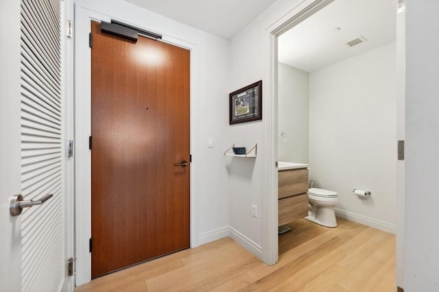 bathroom featuring hardwood / wood-style flooring, vanity, and toilet