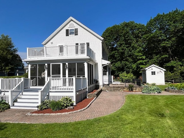 680 Old Connecticut Path, Framingham, MA 01701 - back of house featuring a balcony, a sunroom, a lawn, an outdoor structure, and a storage unit