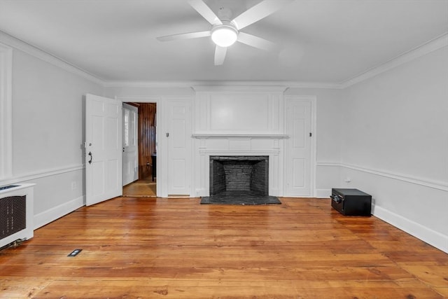 680 Old Connecticut Path, Framingham, MA 01701 - unfurnished living room featuring radiator, light wood-style flooring, crown molding, a fireplace with raised hearth, and a ceiling fan