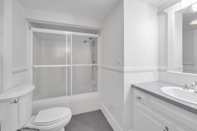 680 Old Connecticut Path, Framingham, MA 01701 - full bath featuring toilet, bath / shower combo with glass door, vanity, tile walls, and wainscoting