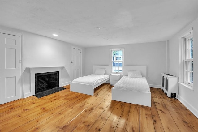 680 Old Connecticut Path, Framingham, MA 01701 - bedroom with heating unit, a fireplace with flush hearth, hardwood / wood-style floors, recessed lighting, and baseboards