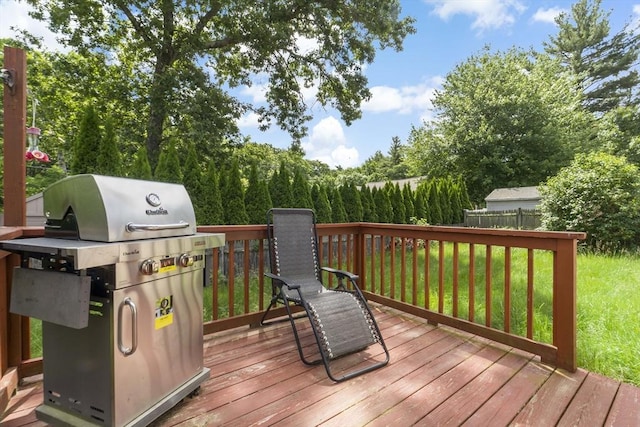 wooden terrace with a lawn and a grill