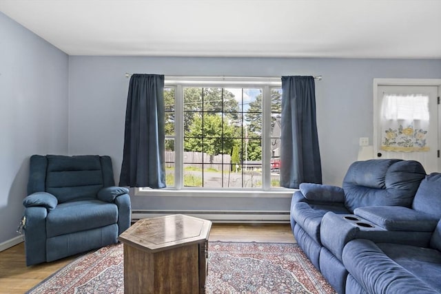 living room featuring wood-type flooring and a baseboard heating unit