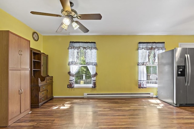 interior space with ceiling fan, dark hardwood / wood-style flooring, stainless steel refrigerator with ice dispenser, and a baseboard heating unit