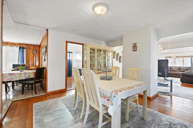 dining room with hardwood / wood-style floors and wood walls