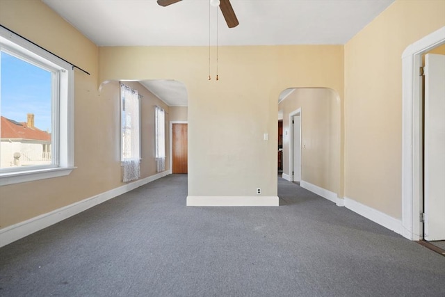 empty room featuring plenty of natural light and ceiling fan