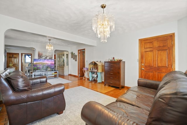 living room with a chandelier and light wood-type flooring