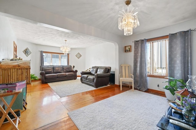 living room with plenty of natural light, hardwood / wood-style floors, and a chandelier