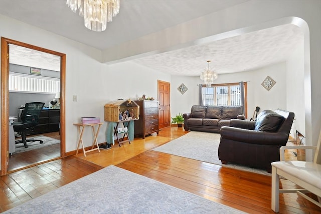 living room featuring an inviting chandelier and hardwood / wood-style floors