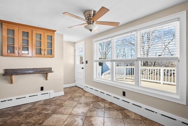 interior space featuring baseboards, baseboard heating, and ceiling fan