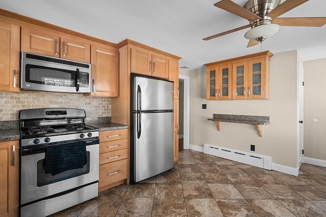 kitchen with decorative backsplash, dark countertops, baseboard heating, and appliances with stainless steel finishes